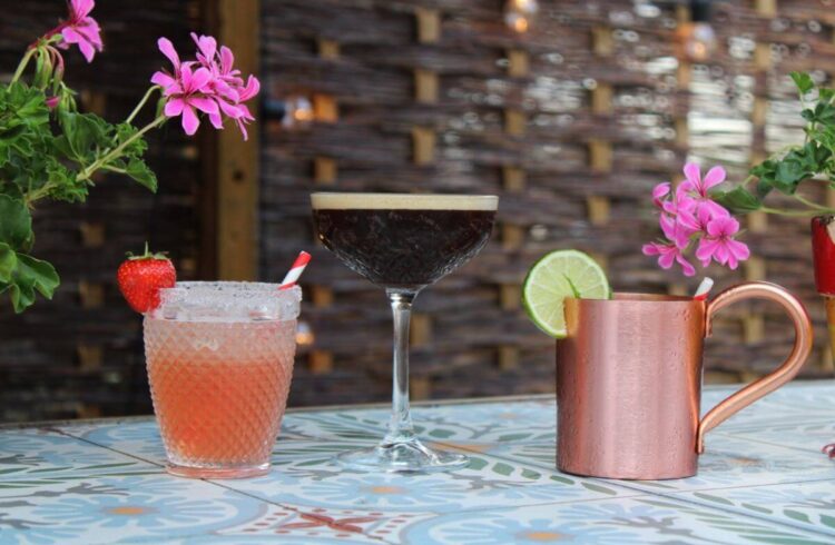 Three cocktails on an outdoor tables