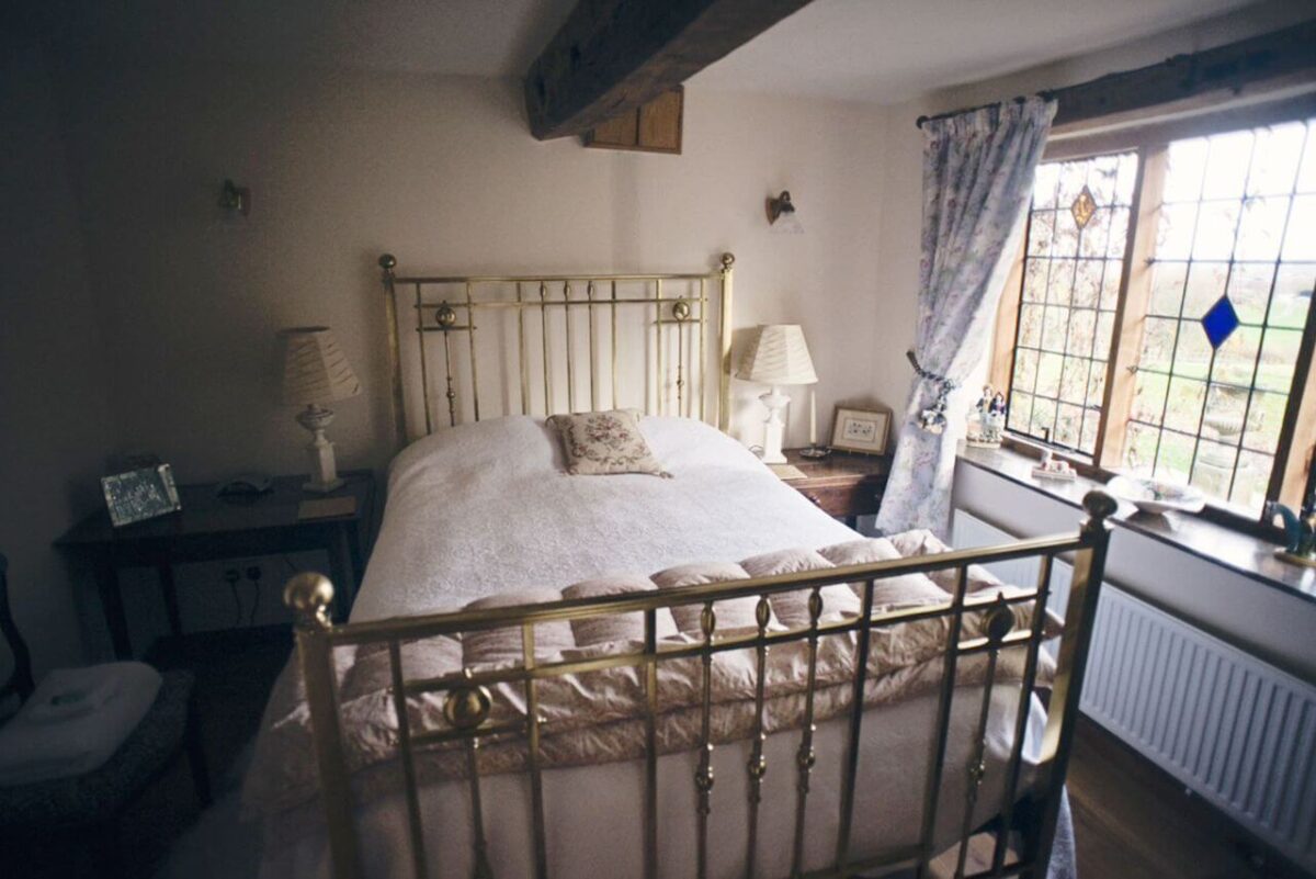 Long Cover Cottage Bedroom with a brass bed with white bedding