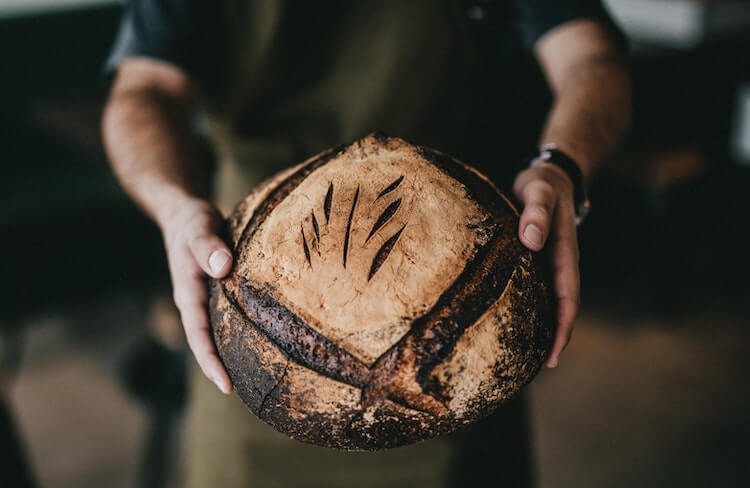 Baker holding up bread