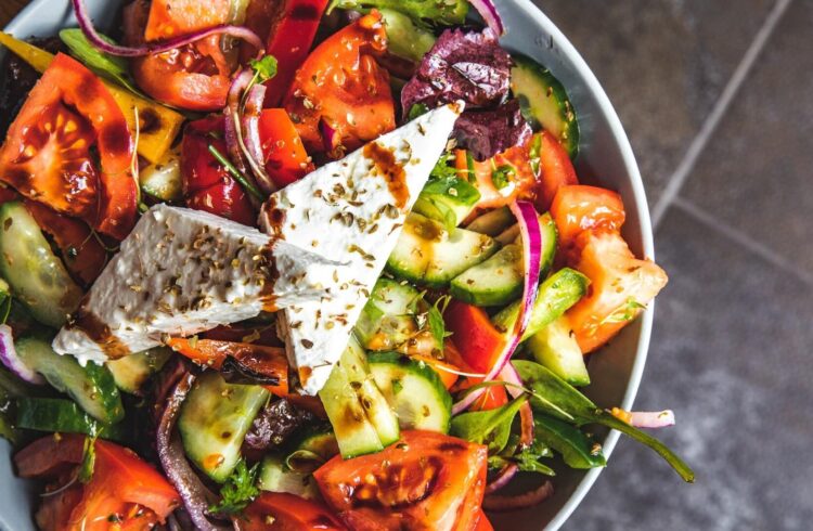 A Mediterranean style dish with tomatoes, red onion, cucumber and feta, with dressing