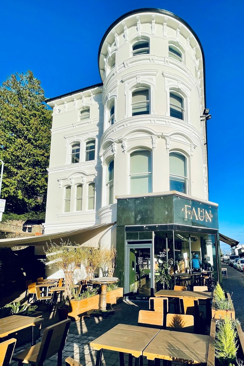 View of the exterior of Faun with outdoor seating in foreground