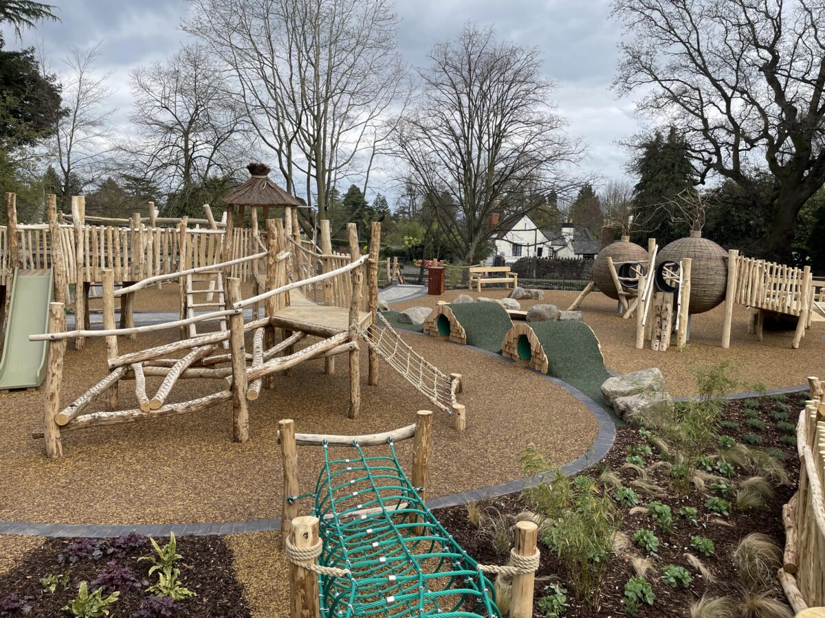 Priory Park Play Area overview of the play area showing wooden climbing apparatus, hobbit tunnels and play pods