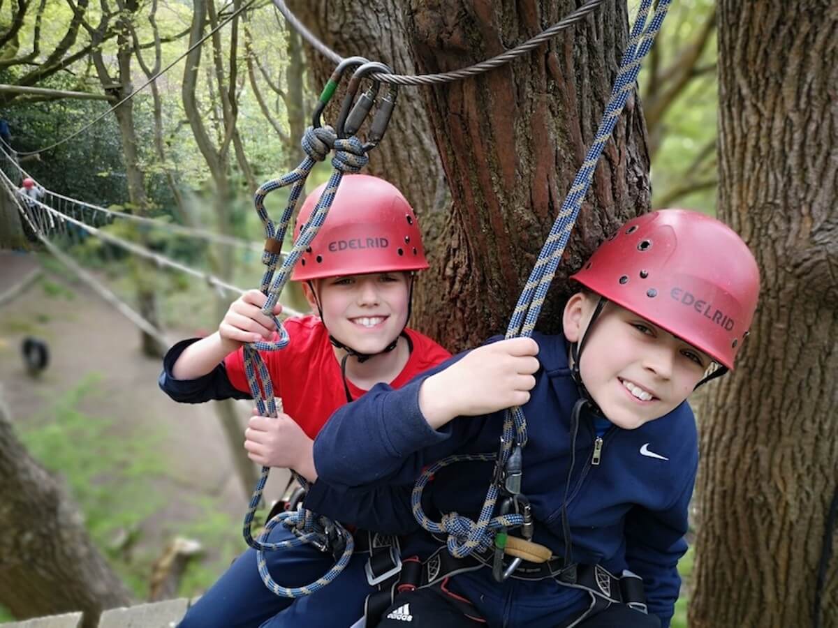 Two boys smile while on high ropes activity