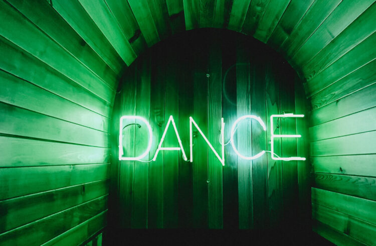 The word DANCE in green neon light