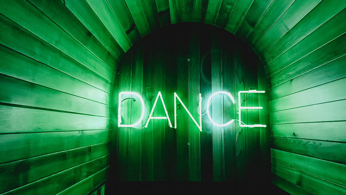 The word DANCE in green neon light