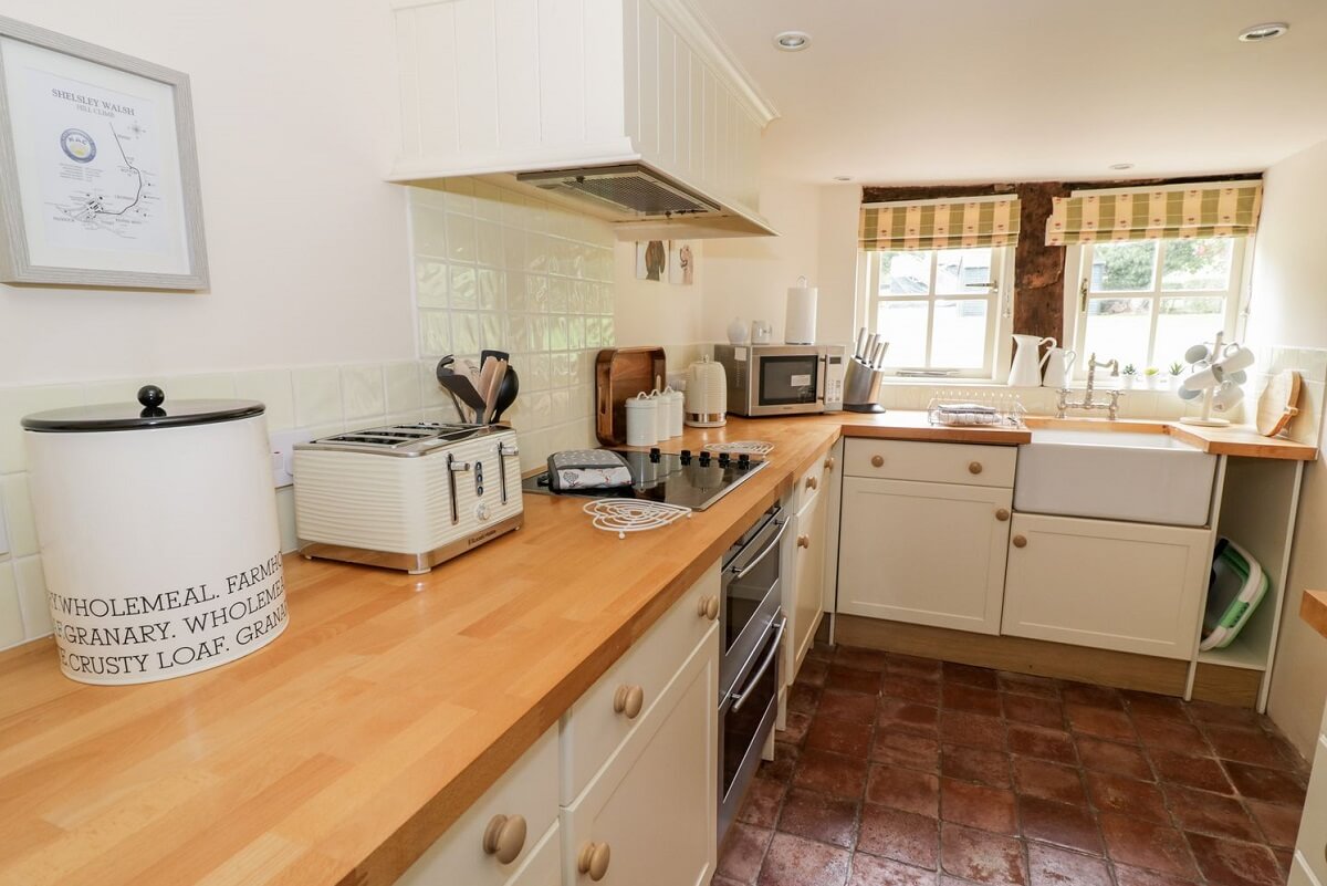 Kitchen with work surfaces, cupboards, toaster, kettle, microwave, oven, hob and sink