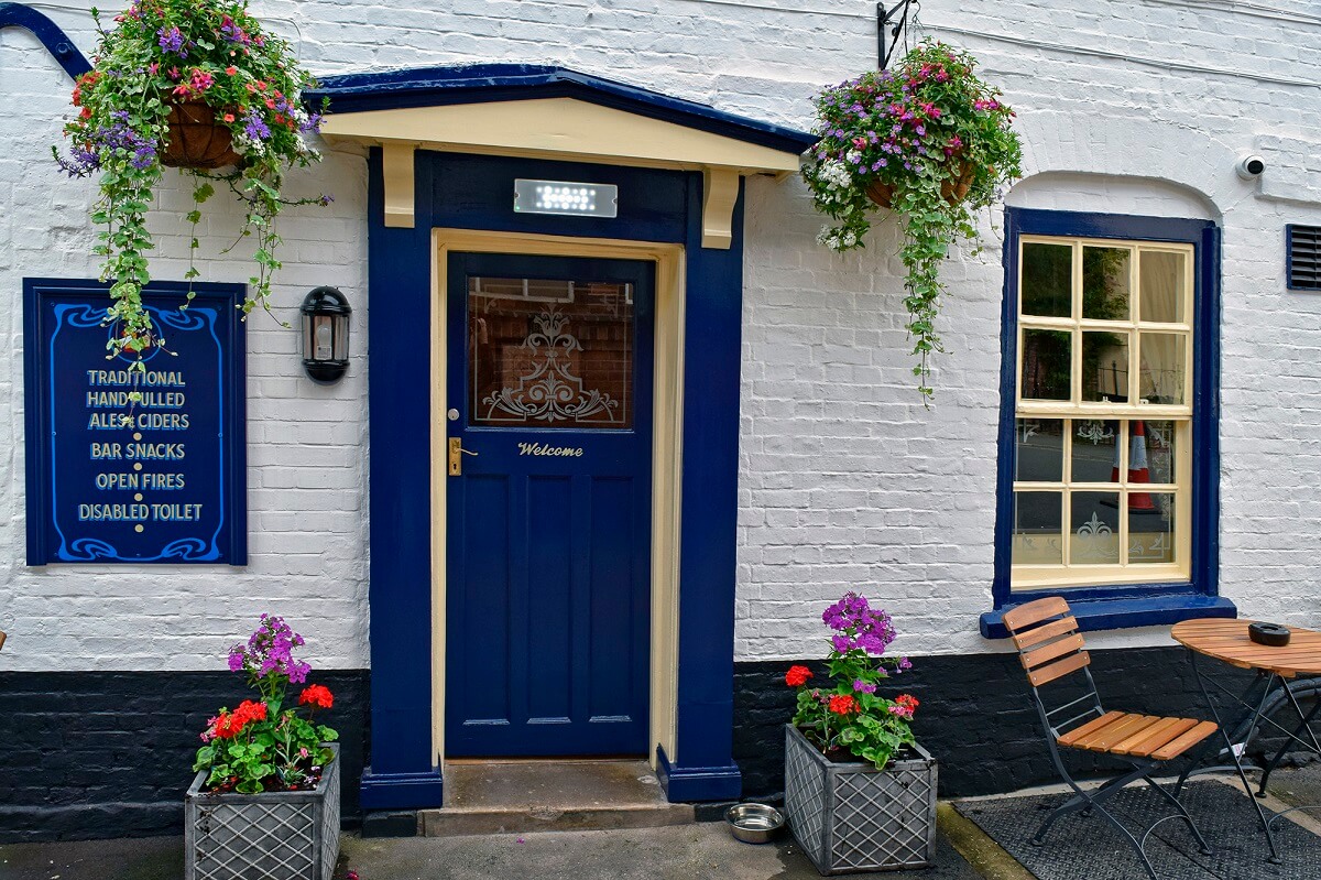 Pub entrance door, with hanging baskets and plant pots