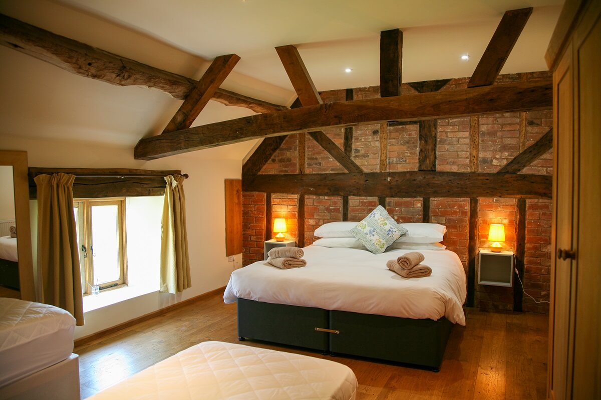 Bedroom with timber frame of cottage visible