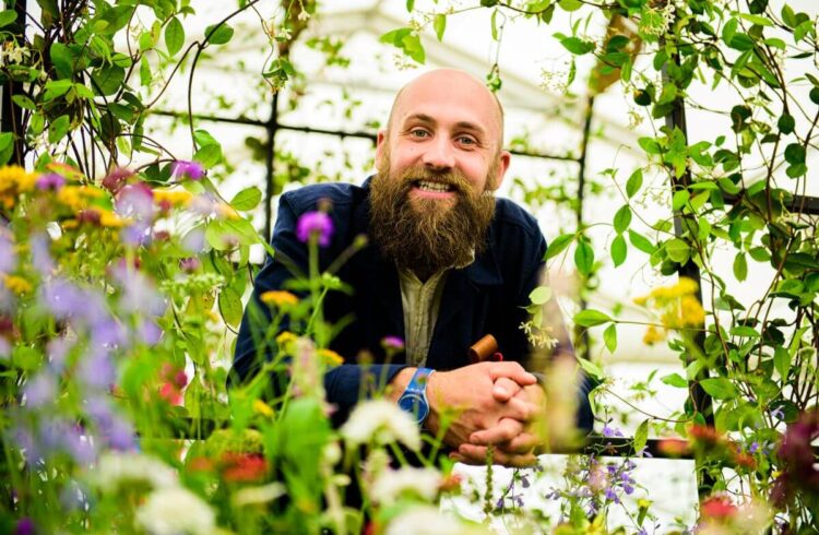 a person surrounded by plants in a greenhouse