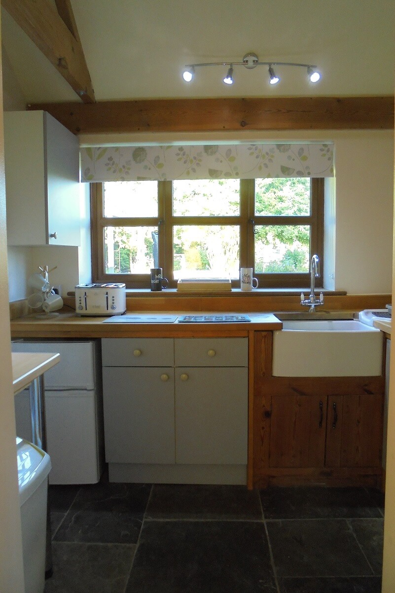 Kitchen area with Belfast-style sink, work surfaces, cupboards, toaster etc.