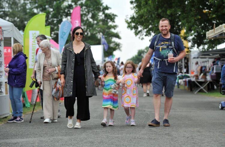 A family of four walk through a festival