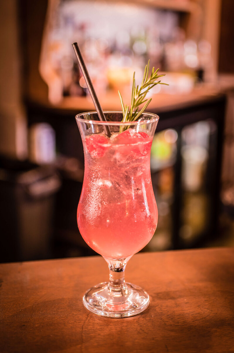 A pink cocktail in a tall glass
