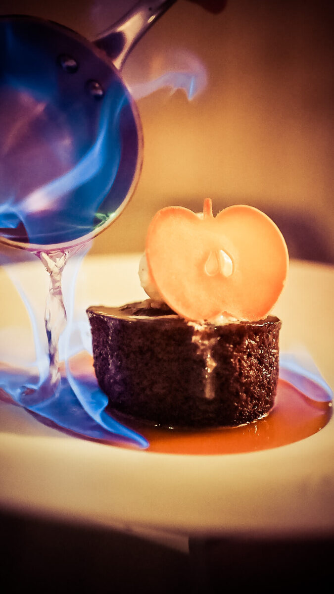 A desert with flambeed alcohol and dried pear