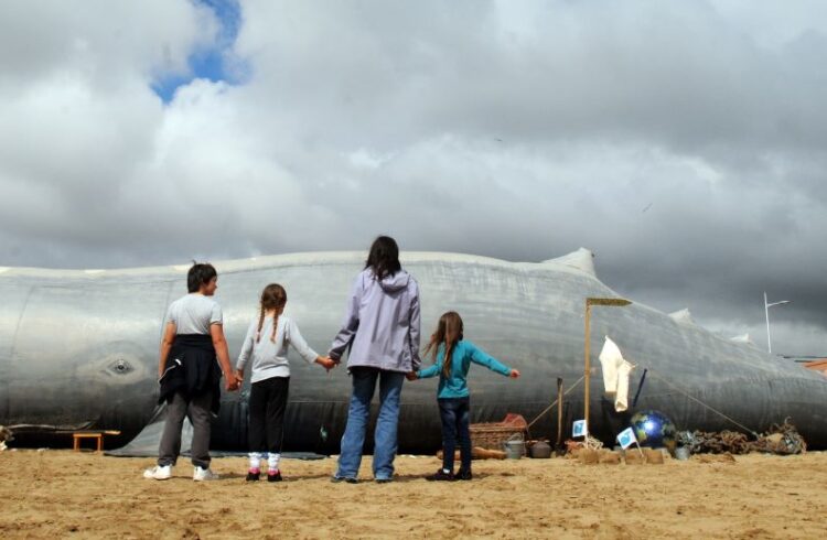 A family looking at a fake beached whale
