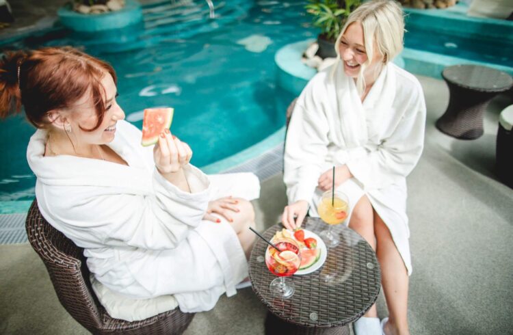 Two people eat watermelon at a spa