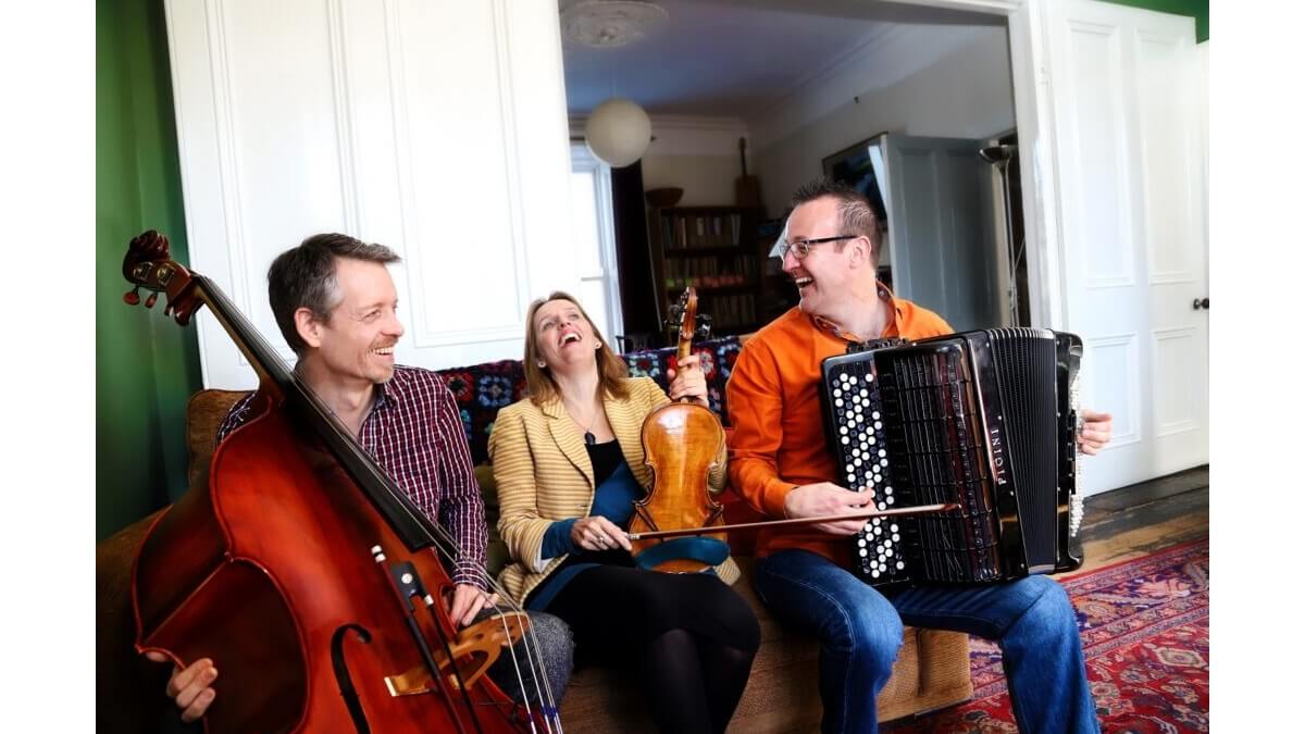 Members of the Far Flung Trio seated on a sofa
