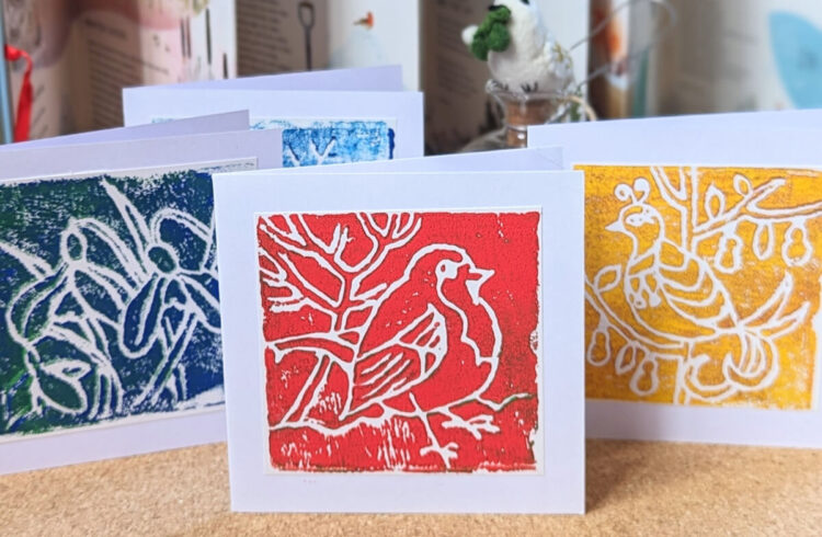 Images of Lino printed Christmas cards. A robin in red ink, snowdrops in blue ink