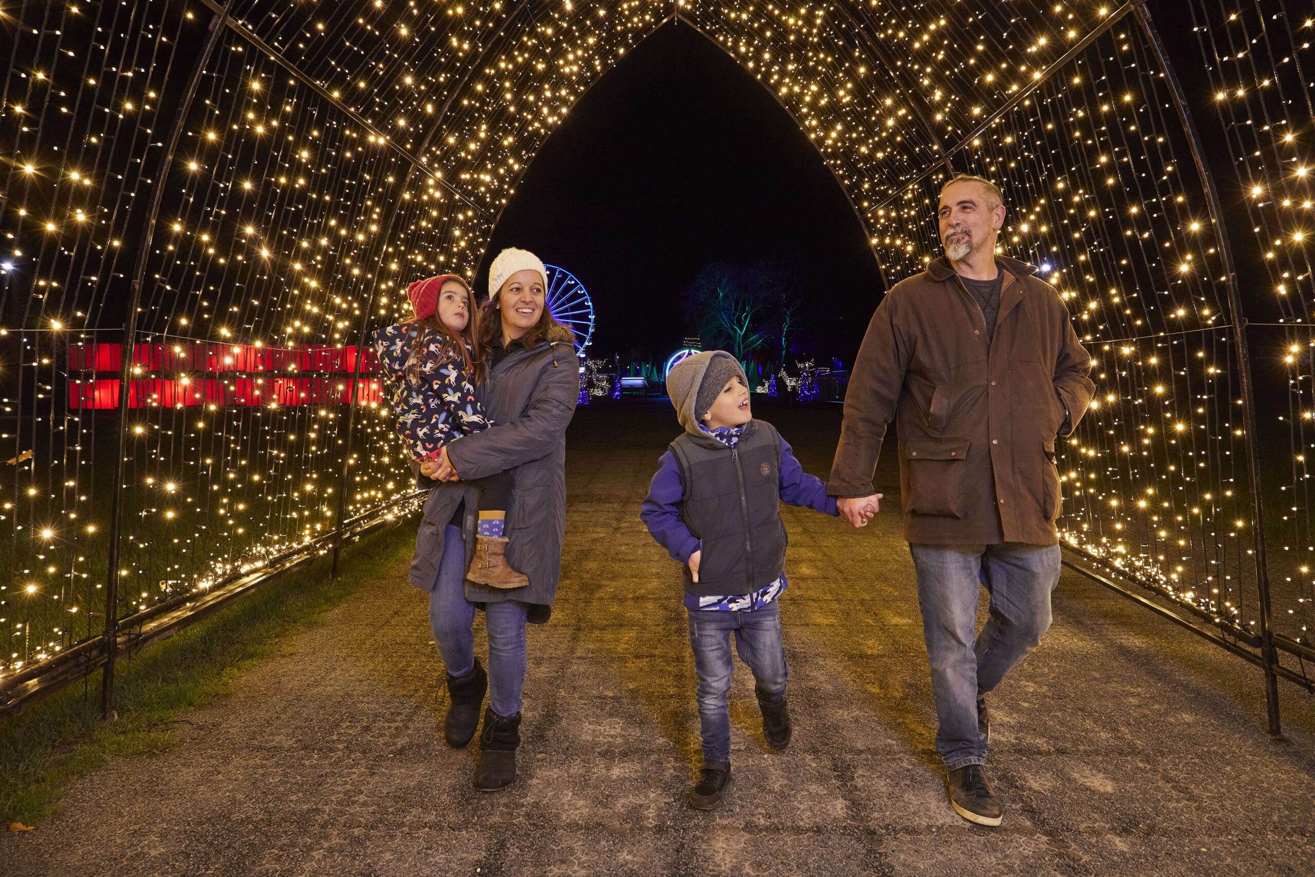 a family walking through christmas lights