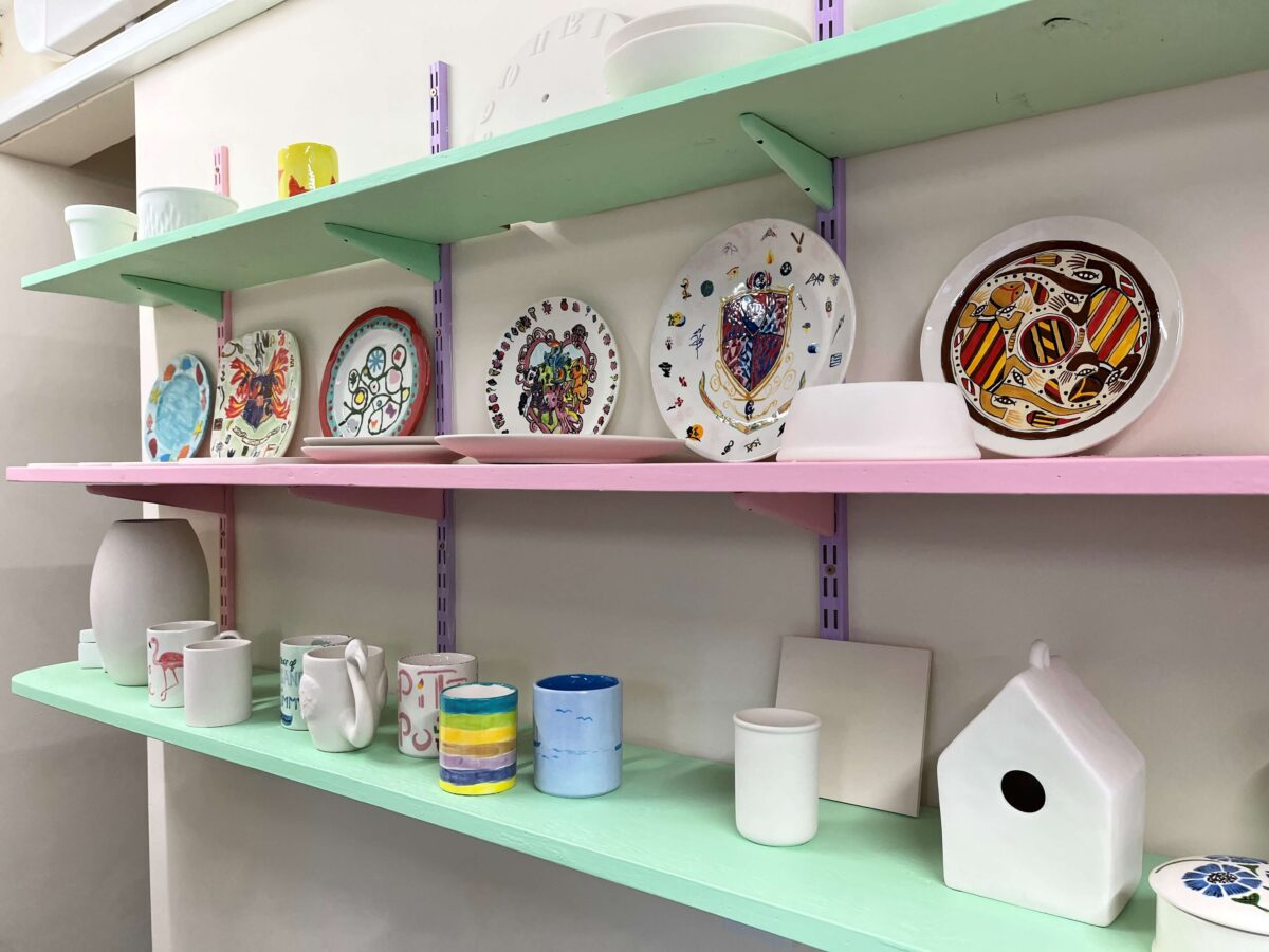 hand painted pottery on pastel shelves