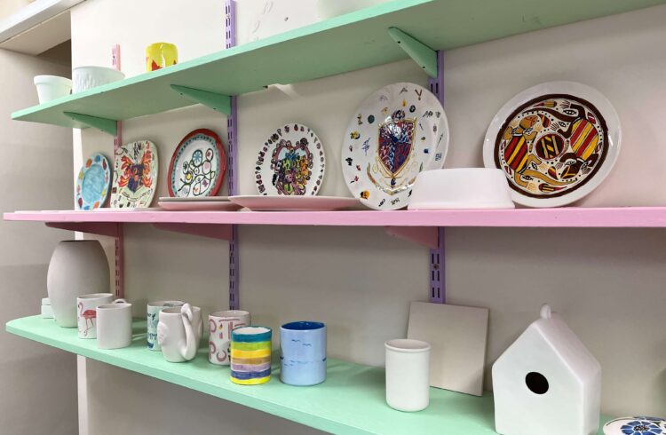 hand painted pottery on pastel shelves