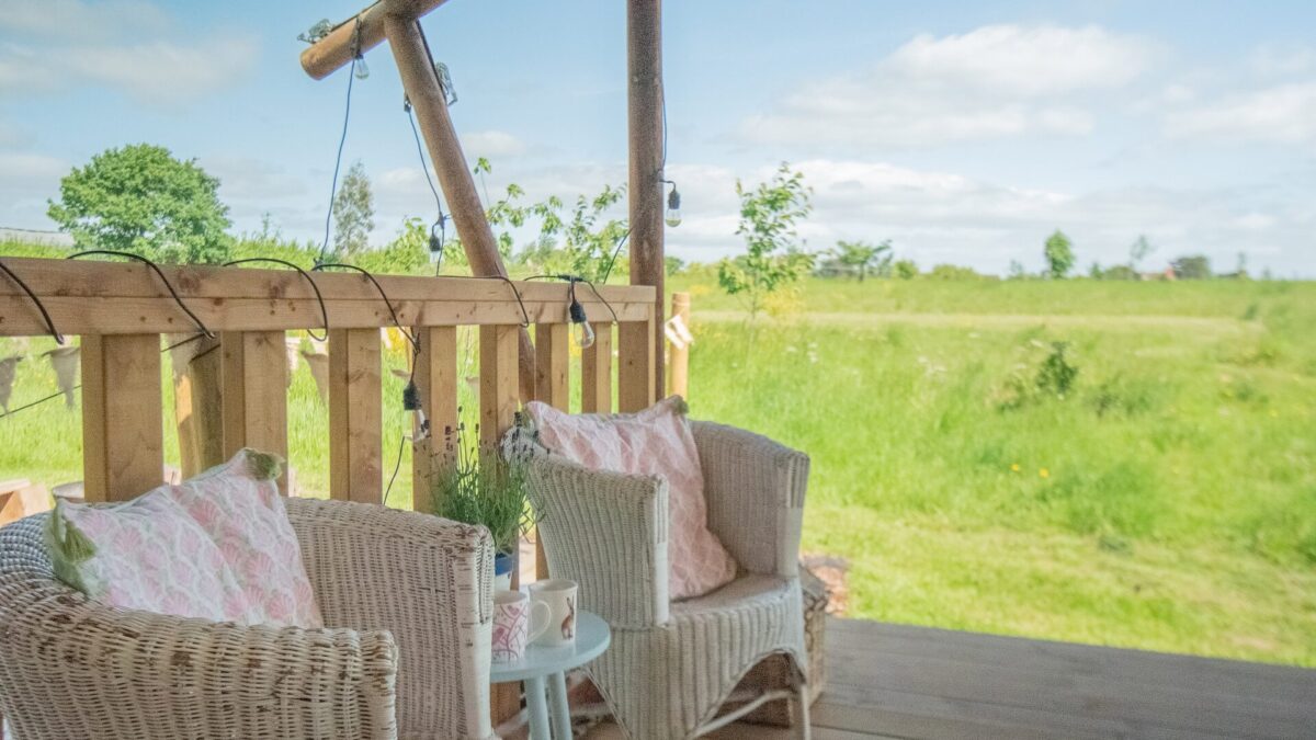 Seats and table on decking with view over surrounding countryside
