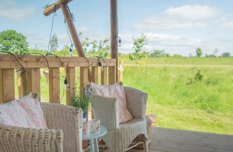Seats and table on decking with view over surrounding countryside