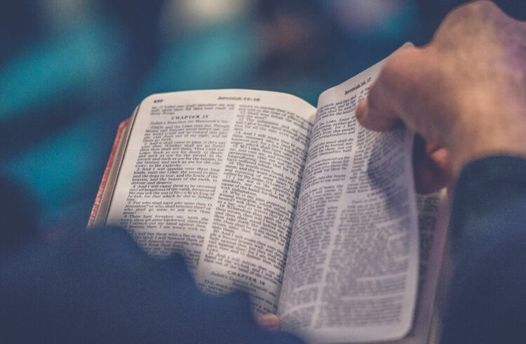 A hand turning the page of Bible