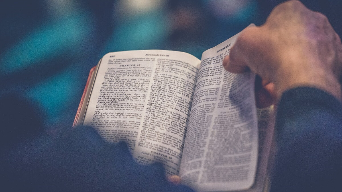 A hand turning the page of Bible