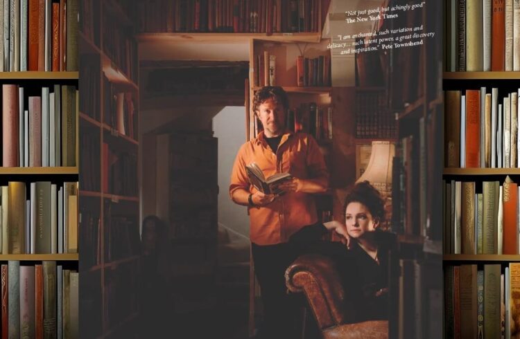 Two members of the band: one seated and one standing in a bookshop