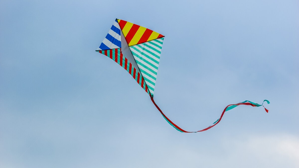 A multicoloured stripy kite flying in the sky