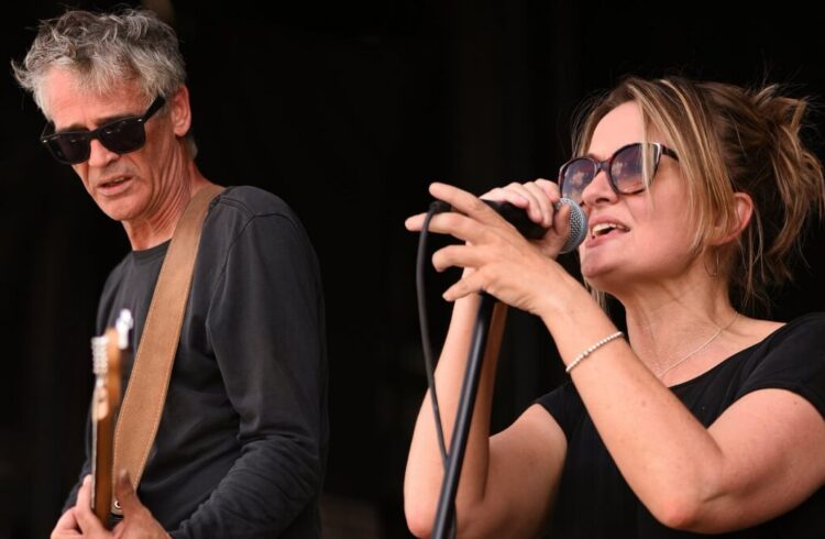 Two musicians from the band Skewwhiff performing - one playing a guitar and the other singing