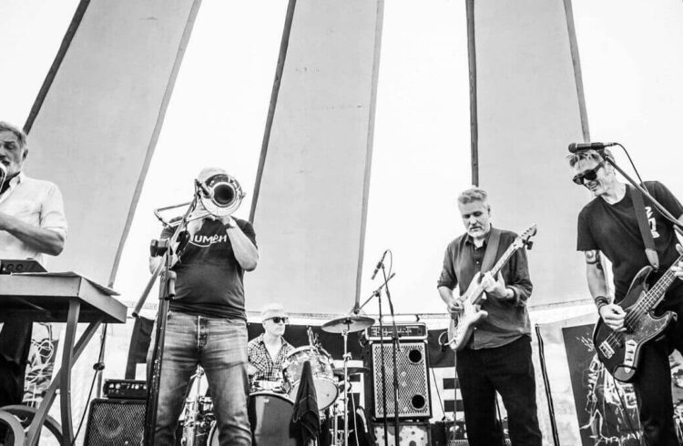 B&W photo of five members of the band Earl Temple Foundation playing a concert