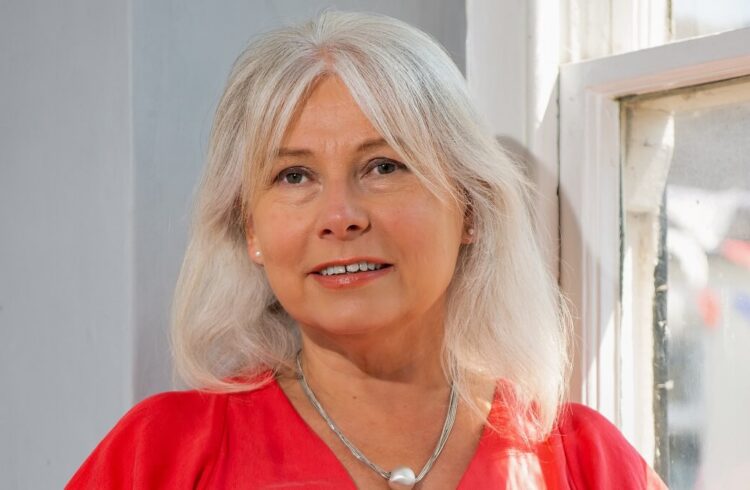 Photo of Melita Thomas wearing a red top and silver necklace