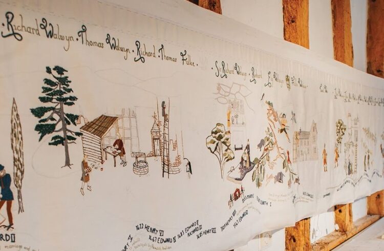 An intricately embroidered design depicting the history of Hellens Manor