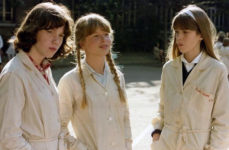 A group of three girls dressed in identical coats