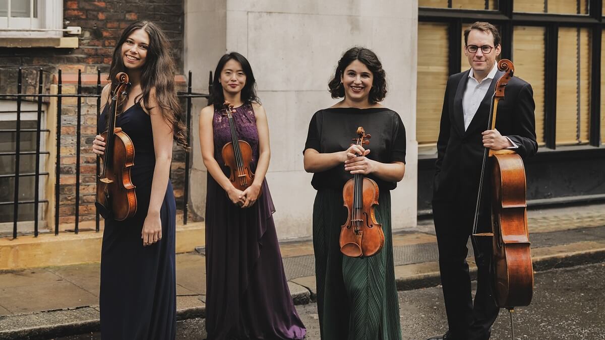 The members of the quartet, dressed for a performance and holding their instruments