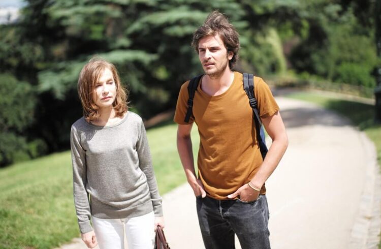 A still from the film showing a man and a woman walking along a path