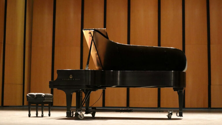 A grand piano and a stool on a stage