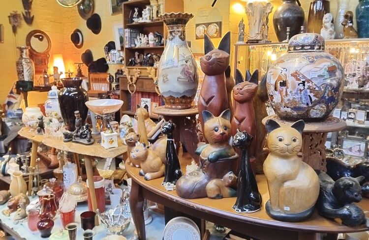 A variety of antiques/collectables arranged on shelves