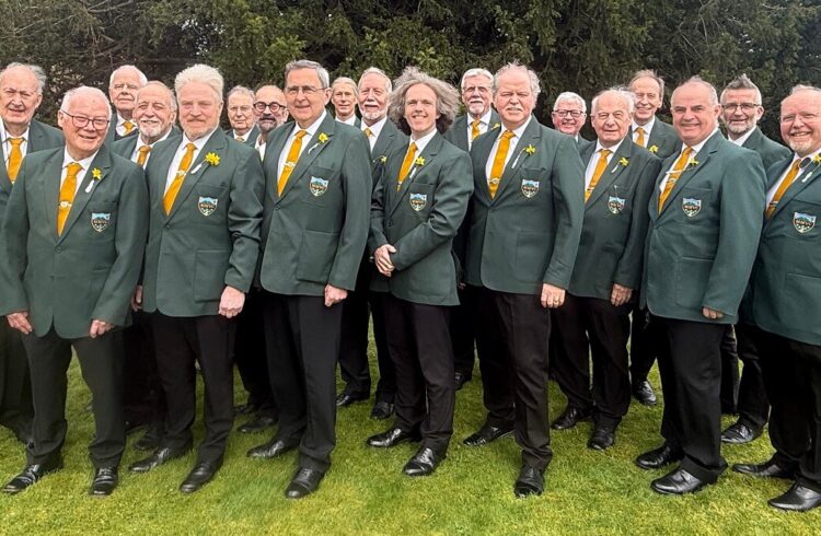 Members of the choir dressed in green blazers and black trousers