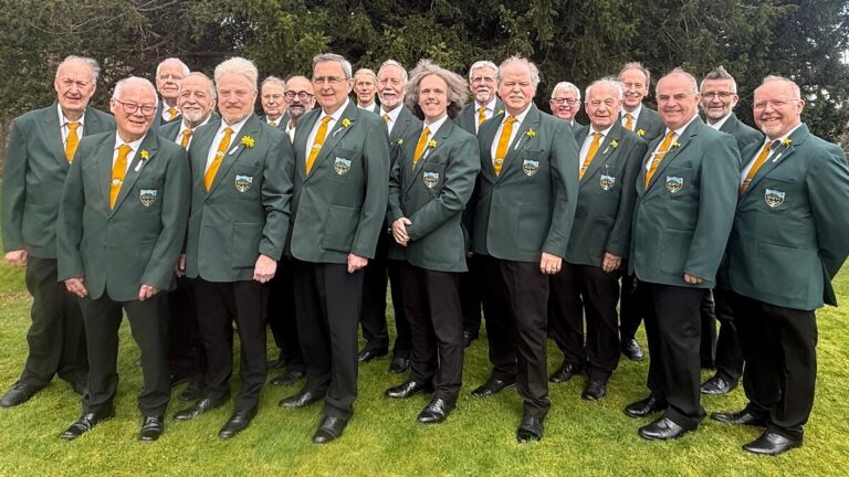 Members of the choir dressed in green blazers and black trousers