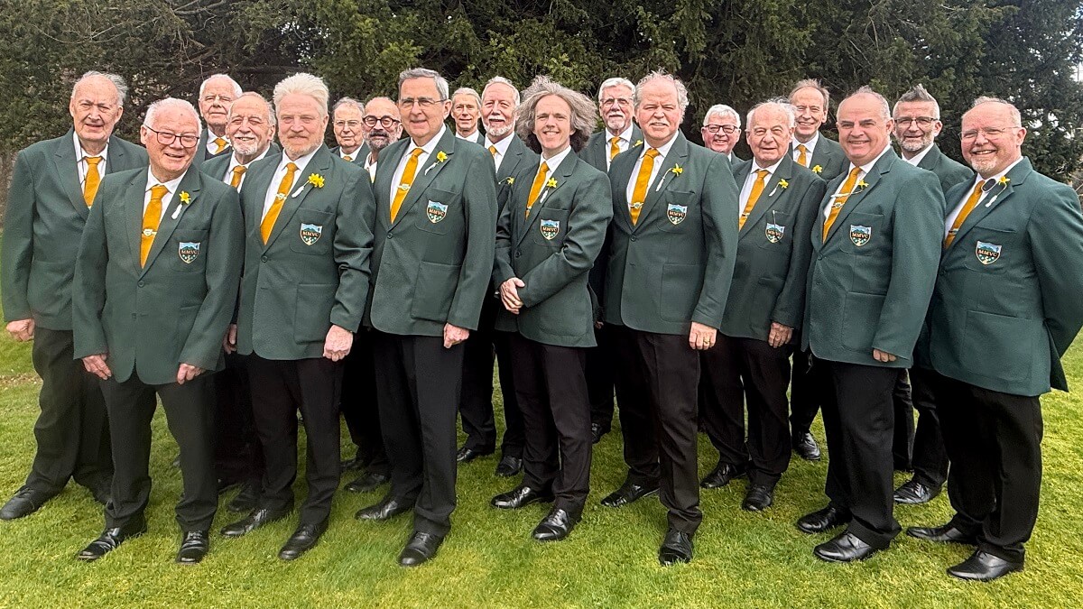 Members of the choir dressed in green blazers and black trousers