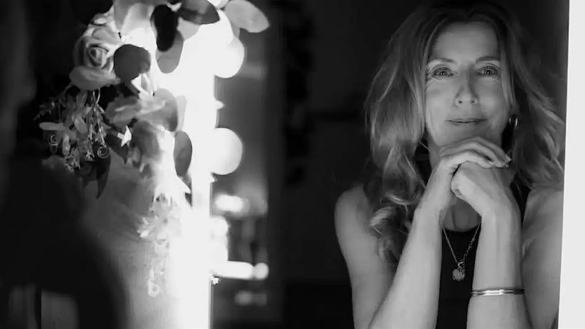 A B&W image of some lights (on the left) and a woman looking directly at camera (on the right)