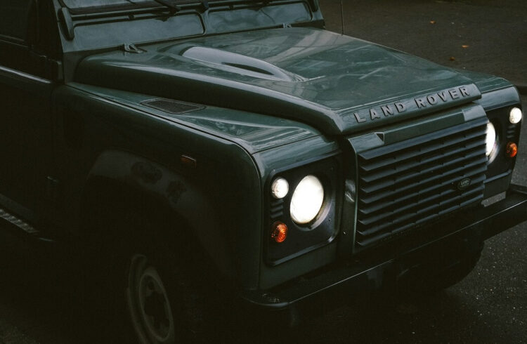 The front of a Land Rover Defender, with lights illuminated