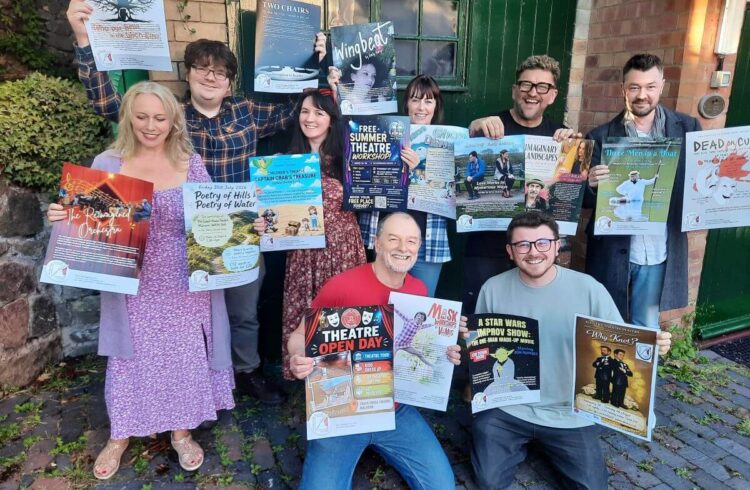 A group of people holding posters for theatre shows