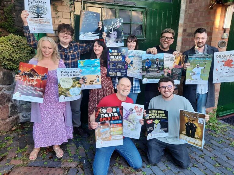 A group of people holding posters for theatre shows