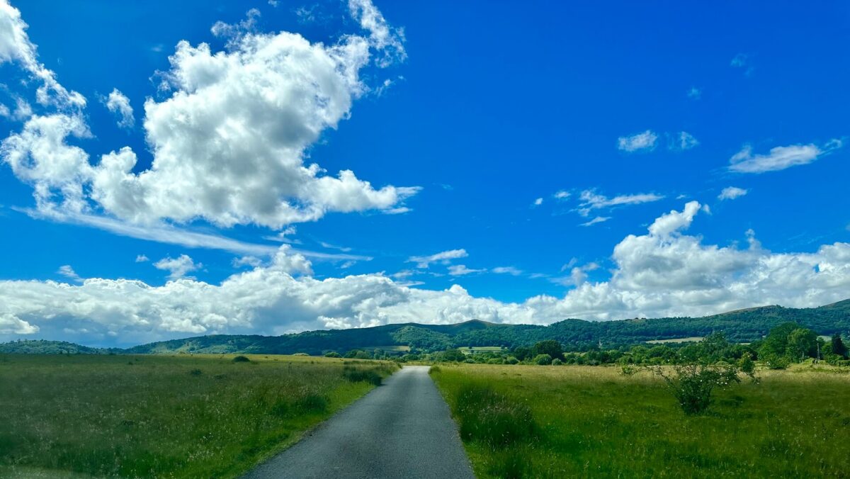 A view over open land towards the Malvern Hills, with blue sky above