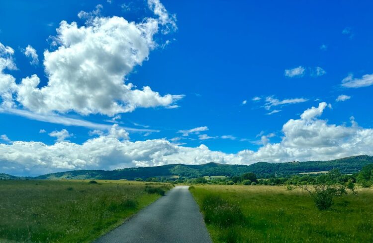 A view over open land towards the Malvern Hills, with blue sky above
